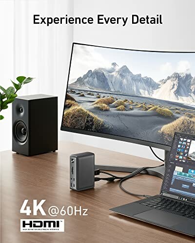 4K monitor setup with laptop and speaker on desk