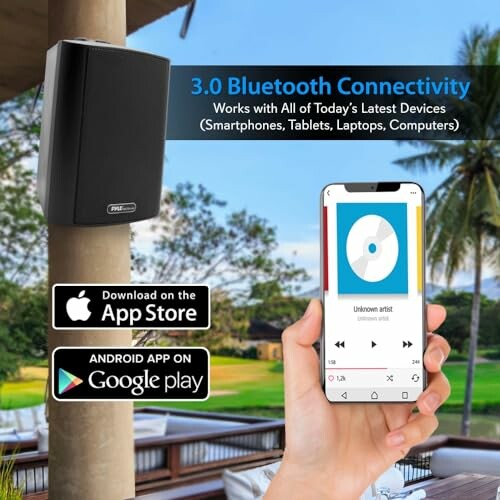 Bluetooth speaker on wall, hand holding smartphone with music app.