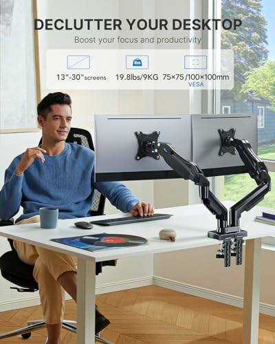 Man using dual monitor arm for desktop organization.